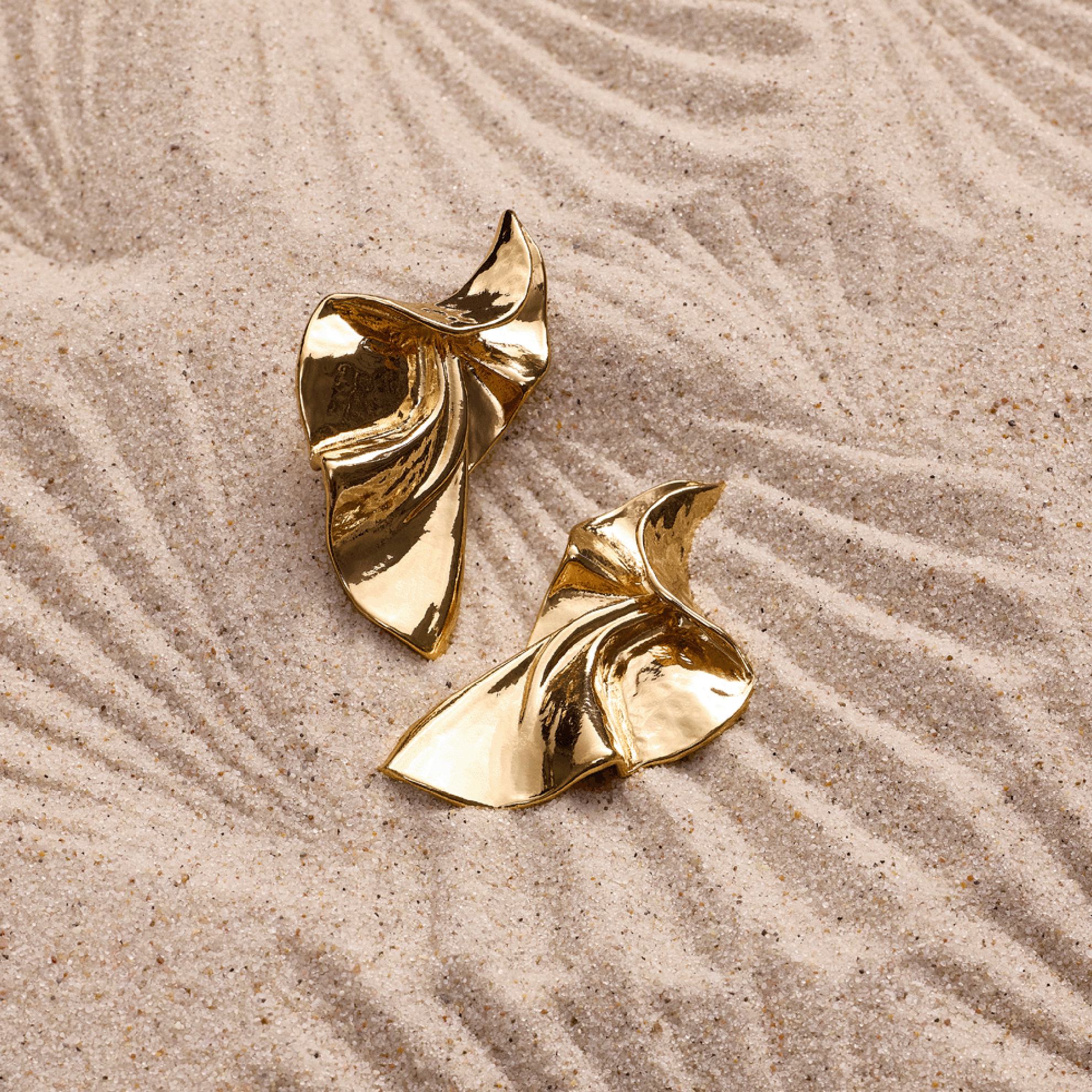 a gold object on sand