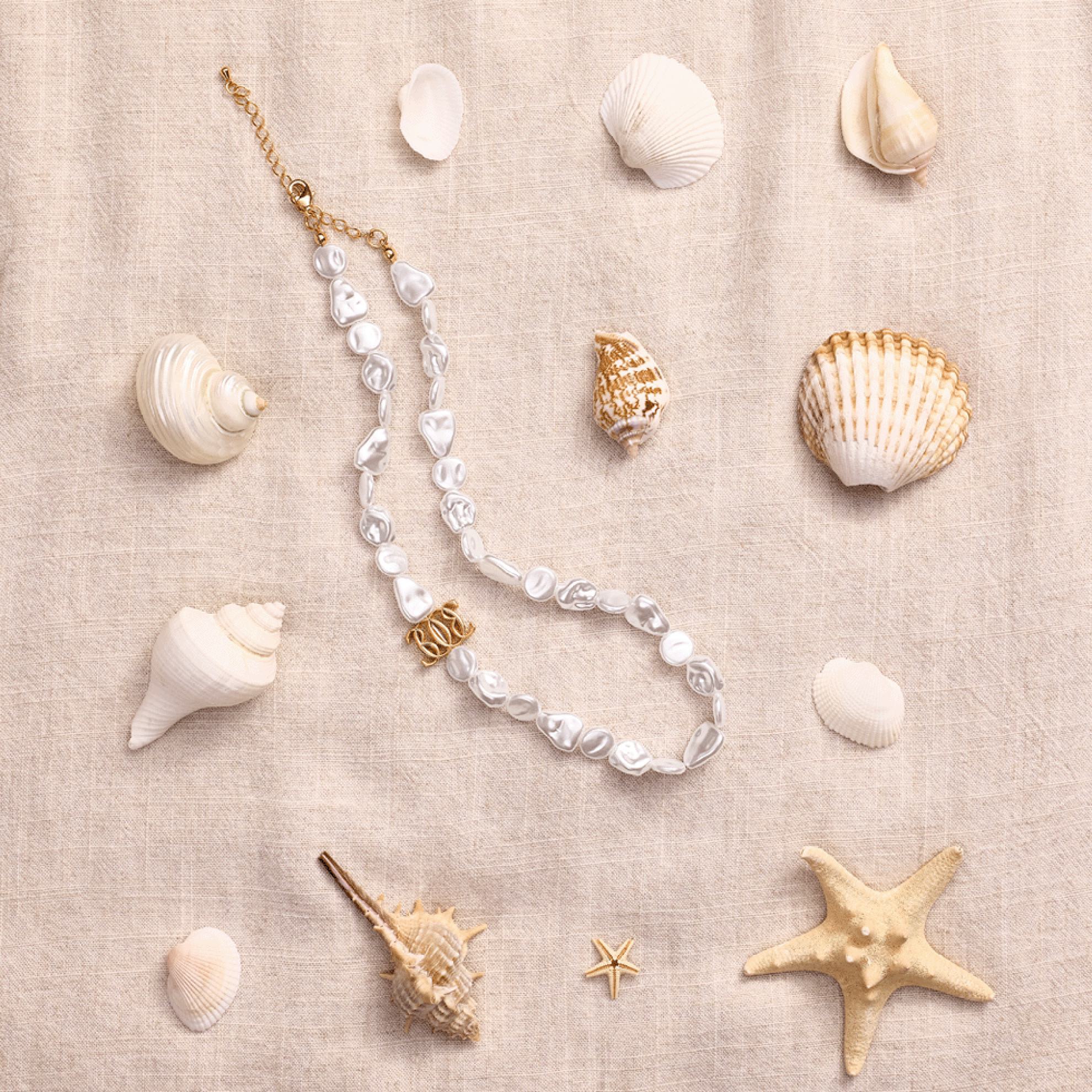 a necklace and seashells on a cloth