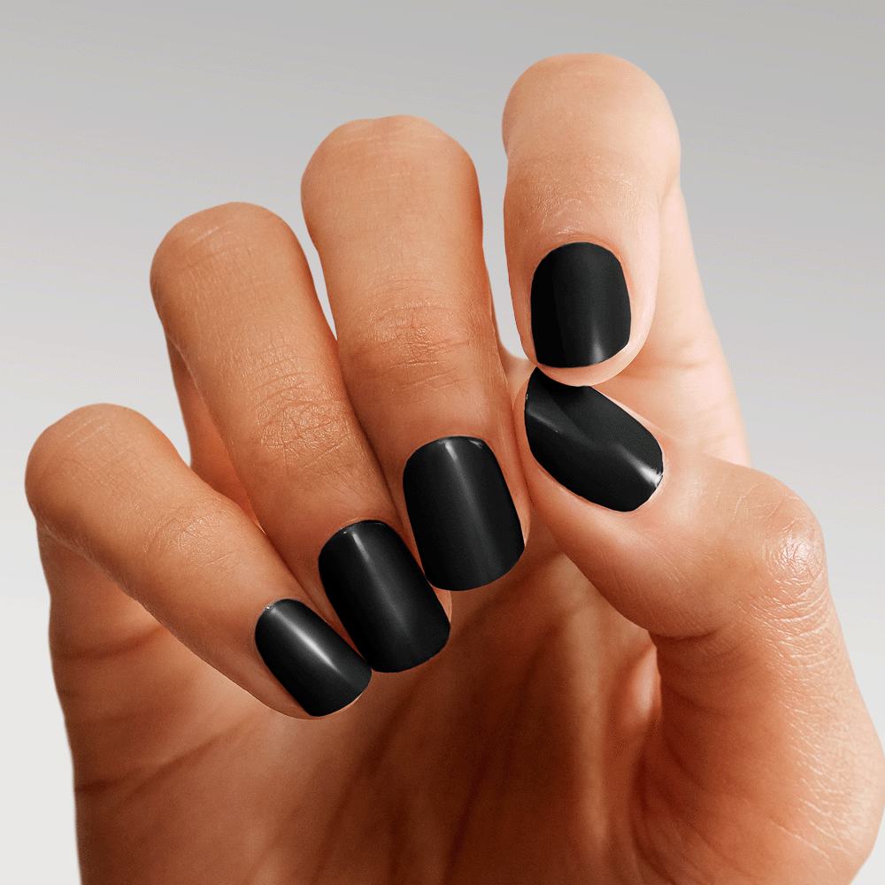 ruka sa crno obojenim noktima