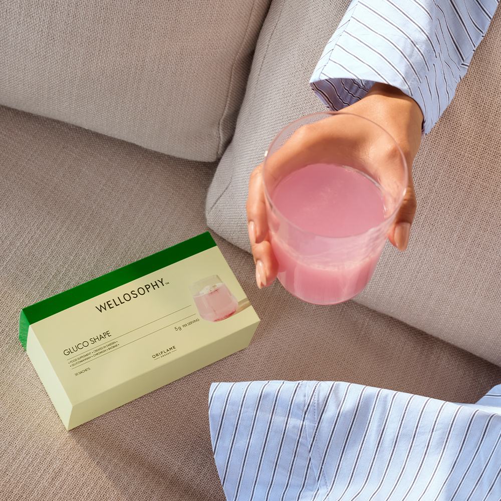 ένα άτομο που κρατά ένα ποτήρι με ροζ υγρό