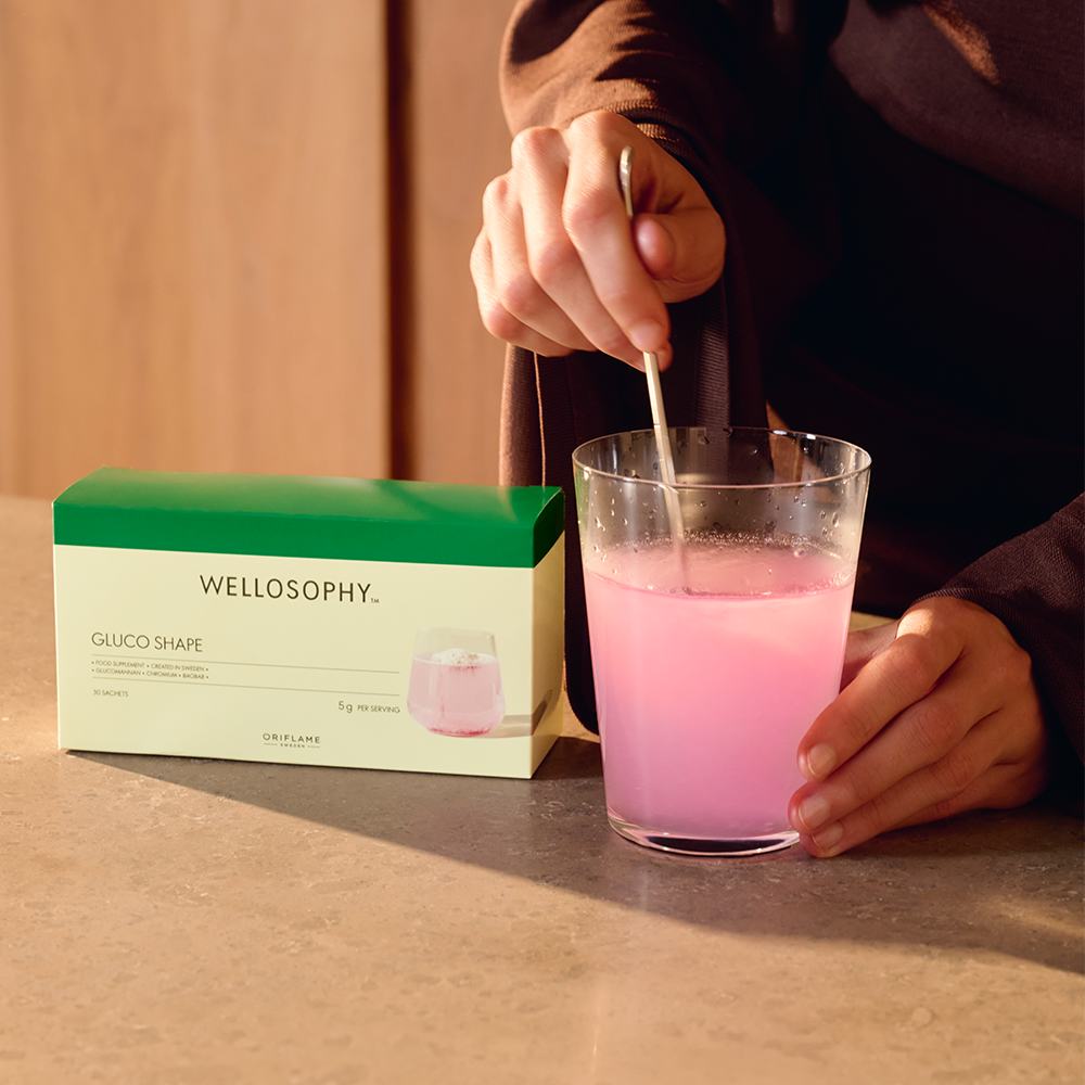 ένα άτομο που αναμιγνύει ένα ροζ υγρό σε ένα ποτήρι