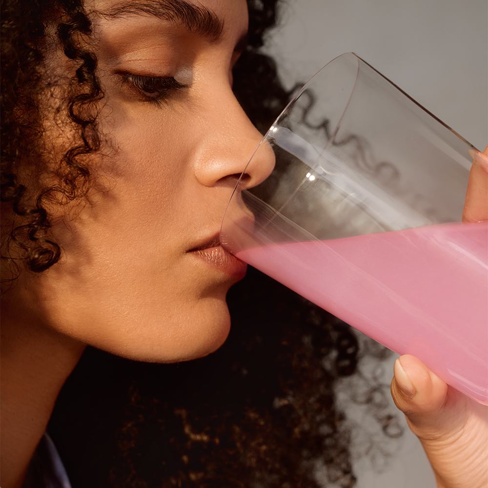 μια γυναίκα που πίνει από ένα ποτήρι